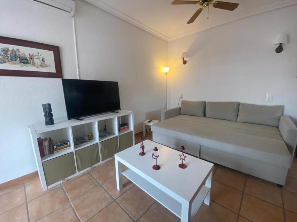 ein Wohnzimmer mit einem Sofa und einem Tisch in der Unterkunft Precioso apartamento silencioso y céntrico in Fuengirola