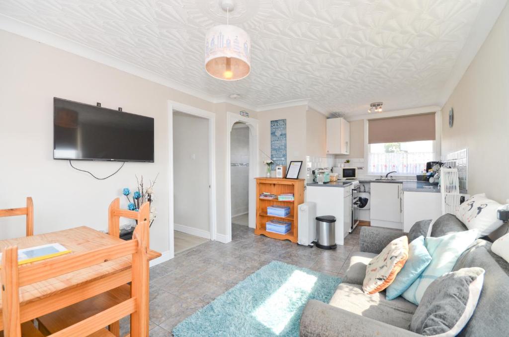 a living room with a couch and a kitchen at 36 Sandown Bay Holiday Centre in Brading