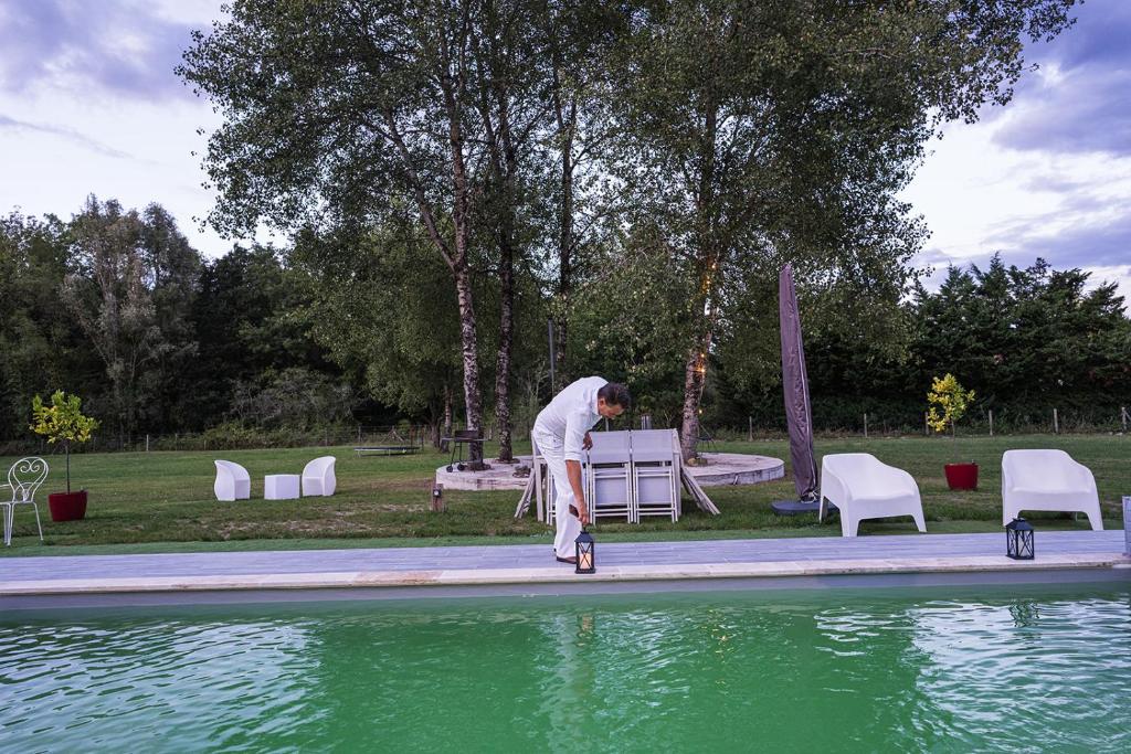 un hombre parado en una patineta cerca de un charco de agua en Nocfond Lodges, en Langon