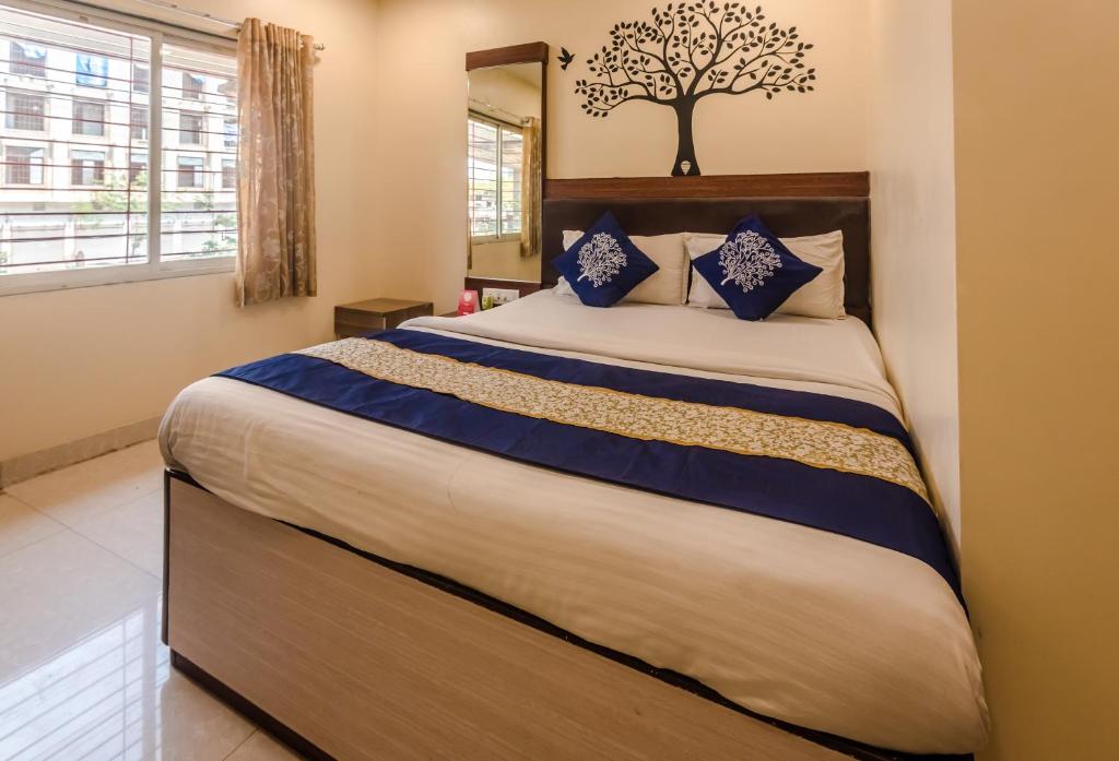 a bedroom with a large bed with blue pillows at OYO Hotel Royal Grand Near Chhatrapati Shivaji International Airport in Mumbai