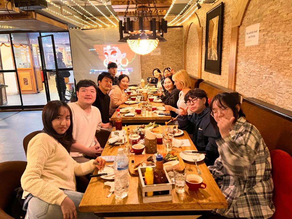 un grupo de personas sentadas en una mesa en un restaurante en Trekkers Home, en Katmandú