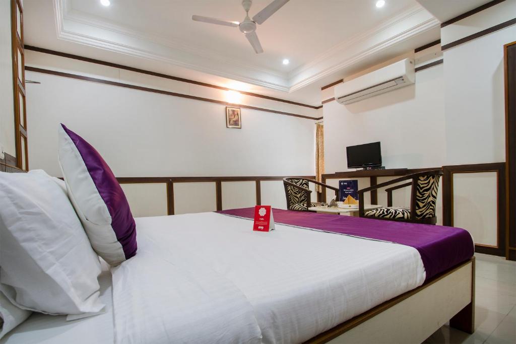 a bedroom with a bed and a tv in it at Hotel Surya Residency in Ameerpet