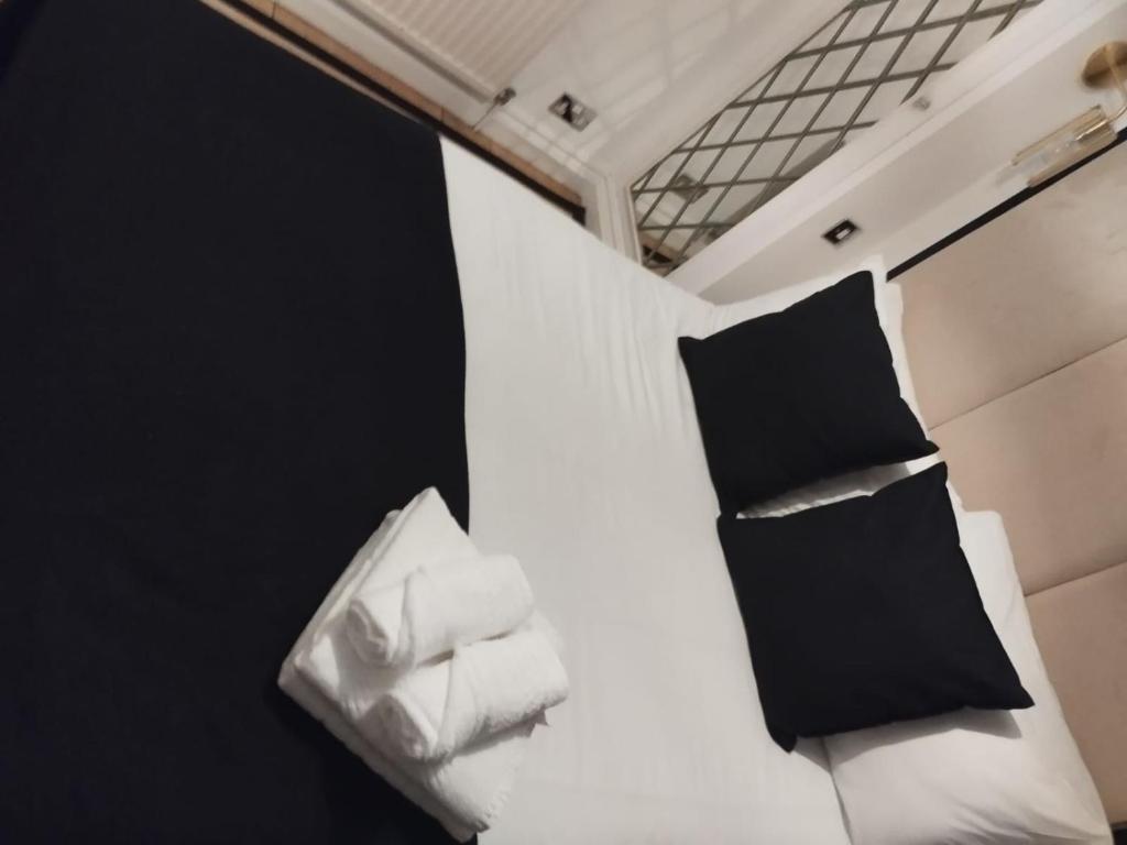 a bed in a room with black and white pillows at Knightsbridge Emerald in London