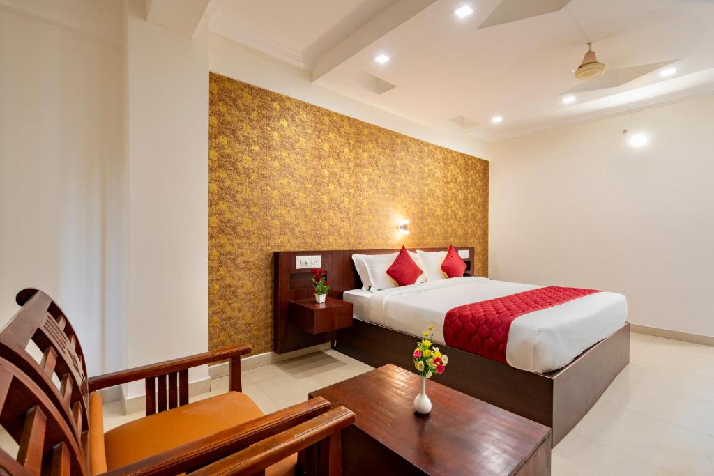 a bedroom with a bed and a table and a desk at Daan Orchid Residency in Kottayam