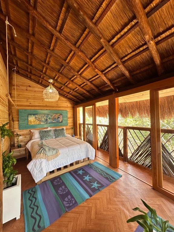 1 dormitorio con 1 cama en una habitación con techos de madera en Cristal Blue Barú, en Barú