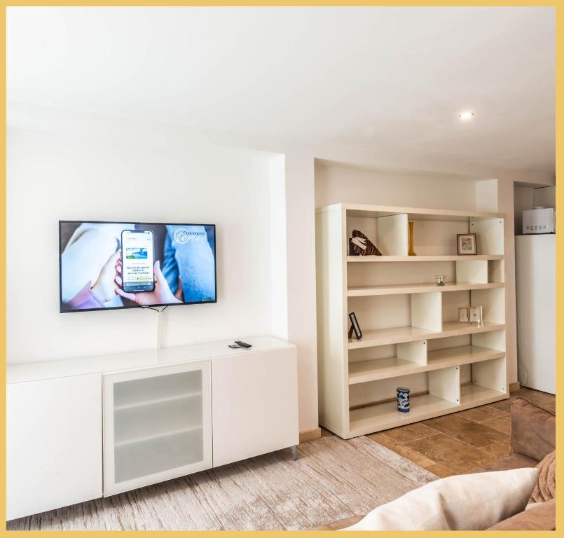 a living room with a tv on a white wall at Appart T3 Luxe Douvaine in Douvaine