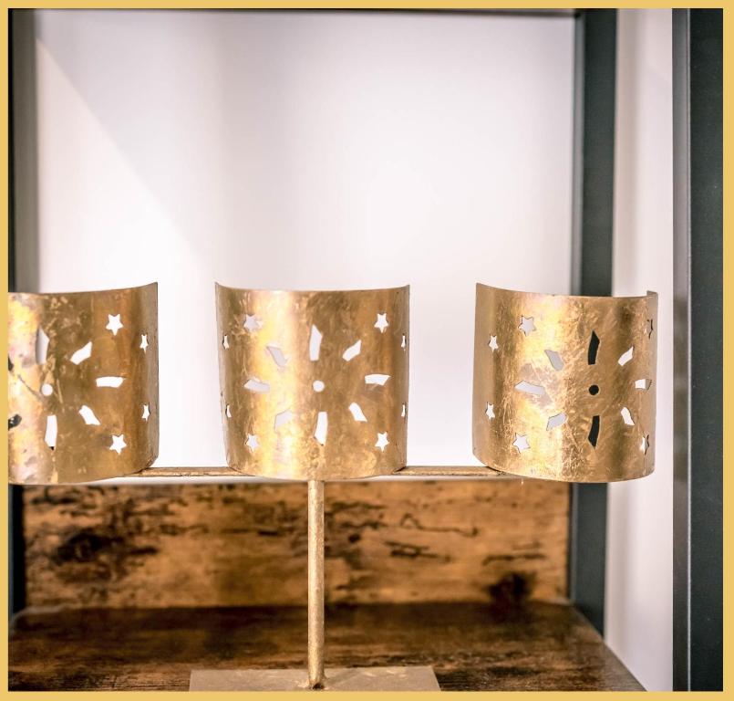 a group of three metal lights on a table at Appart T3 Luxe Douvaine in Douvaine