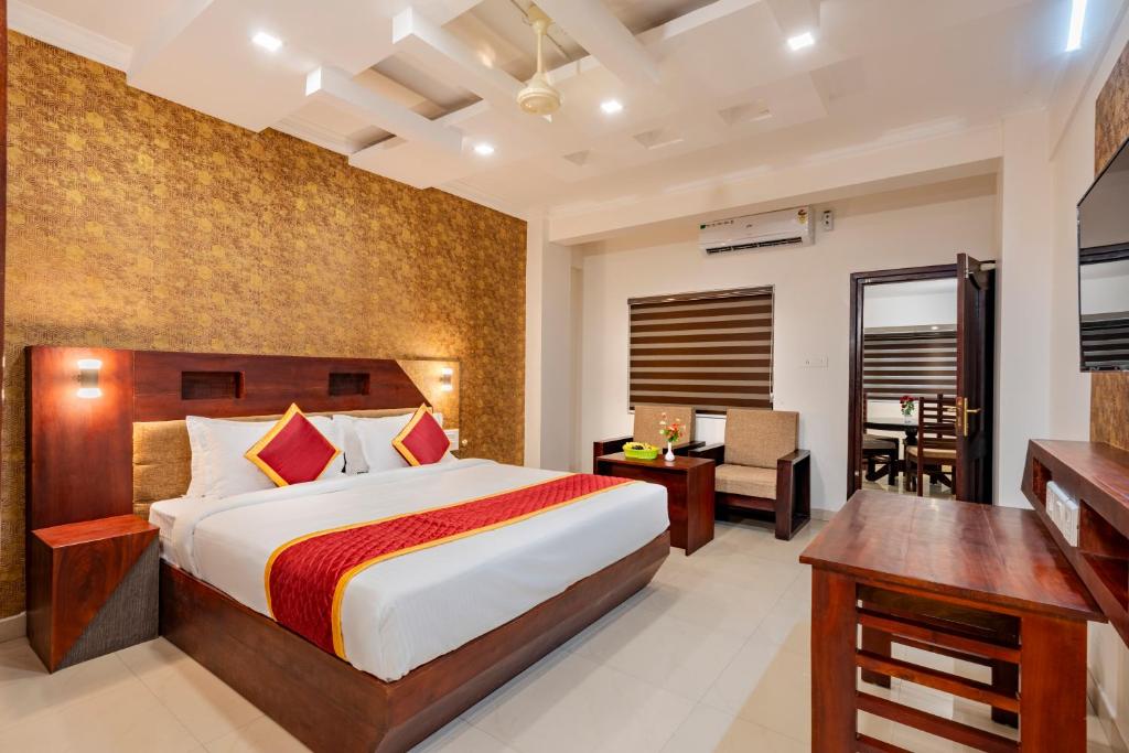 - une chambre avec un lit king-size et un bureau dans l'établissement Daan Orchid Residency, à Kottayam