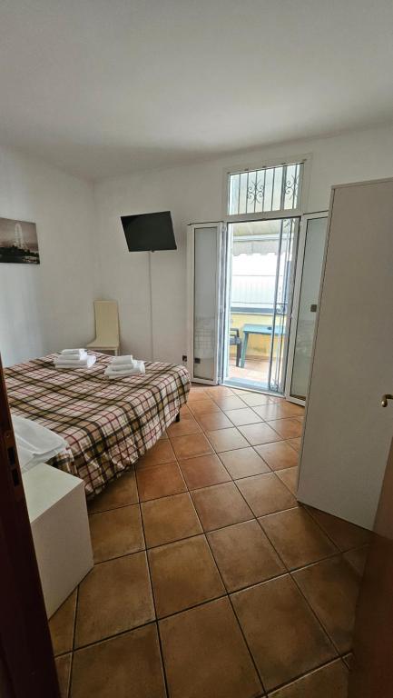 een slaapkamer met een bed en een deur naar een patio bij Appartamenti Fiore 2.0 in Sanremo
