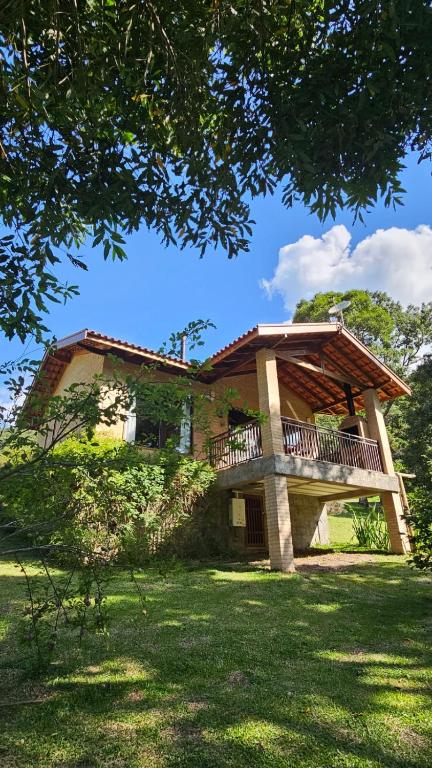 a house with a balcony in the yard at Chalés Boa Vista in Gonçalves