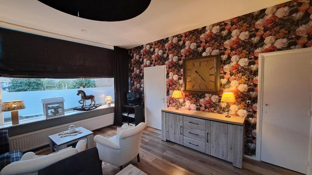 een woonkamer met een klok aan de muur bij Fleurdelis in Lisse