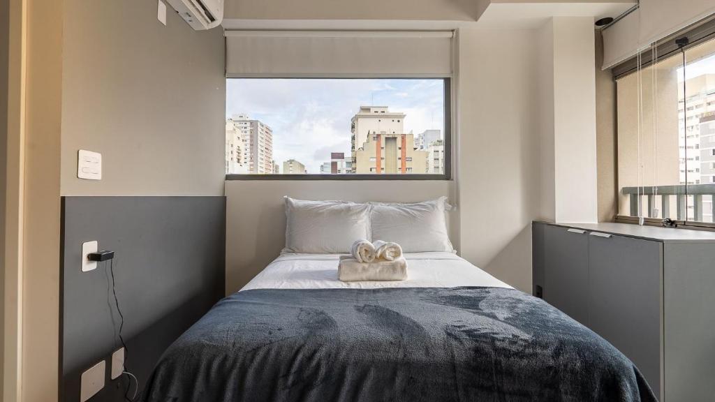 um quarto com uma cama e uma janela grande em Studio no Jardim Paulista prox a Trianon Masp em São Paulo