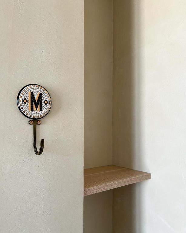 a clock on a wall next to a shelf at Hôtel De La Marine in Arromanches-les-Bains