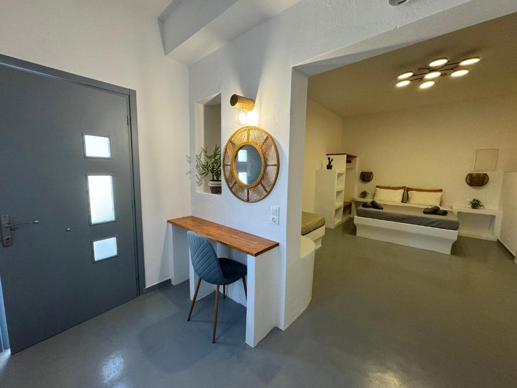 イオス島 チョーラにあるErgina Studiosのテーブル、鏡、ベッド1台が備わる客室です。