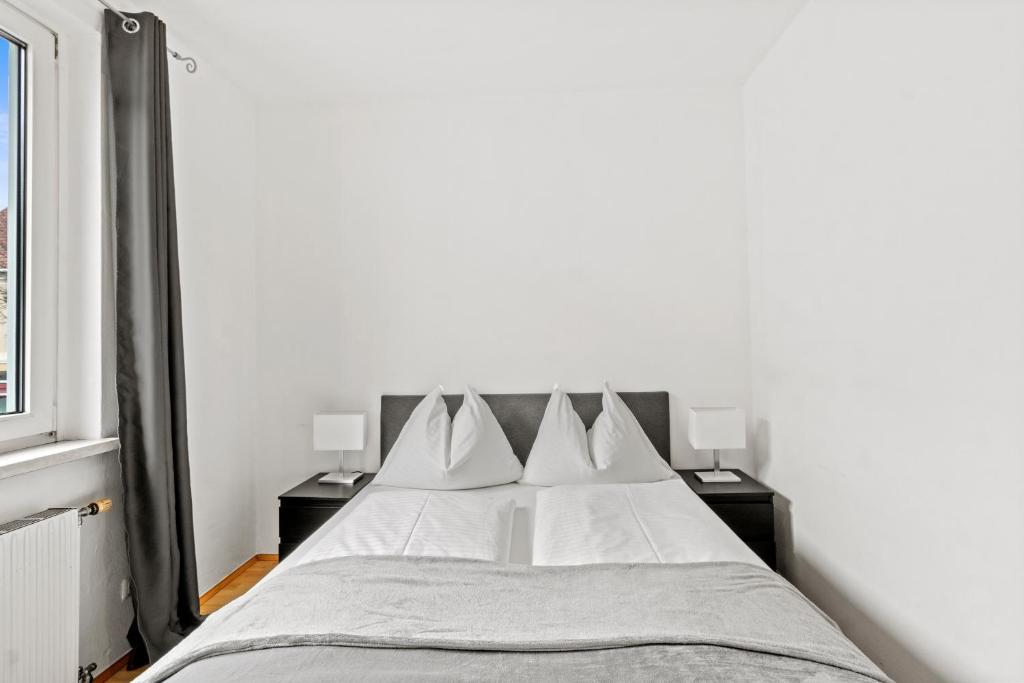 1 dormitorio con 1 cama con sábanas y almohadas blancas en Zentrale Unterkunft am RedBull-Ring, en Fohnsdorf