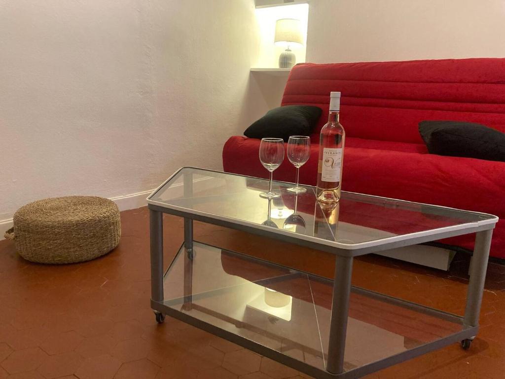 - une table en verre avec 2 verres à vin et une bouteille dans l'établissement Studio, Aix centre historique, à Aix-en-Provence