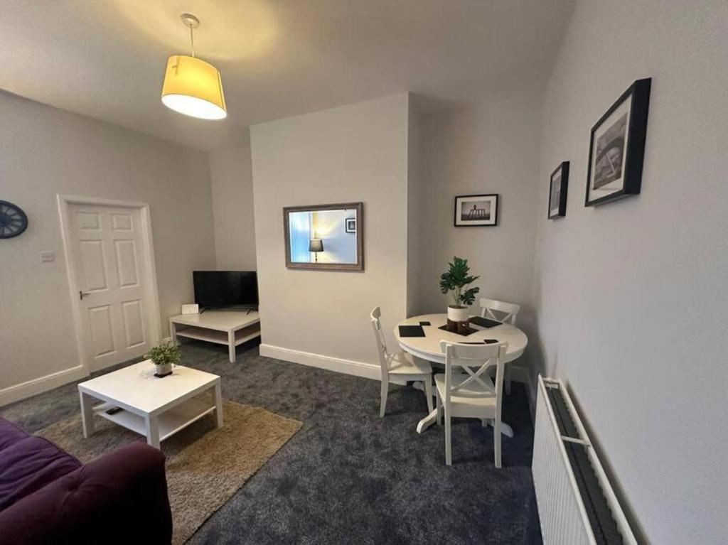 uma sala de estar com uma mesa e um sofá em Hambledon- 2Bed downstairs flat Blyth em Blythe
