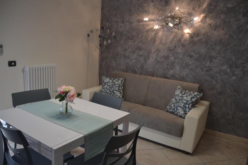 ein Wohnzimmer mit einem Tisch und einem Sofa in der Unterkunft Appartamento Il Volo in Lippo di Calderara di Reno