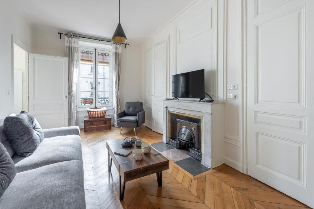 un salon avec un canapé et une cheminée dans l'établissement Gusman - Longue durée dans le 2ème arrondissement, à Lyon