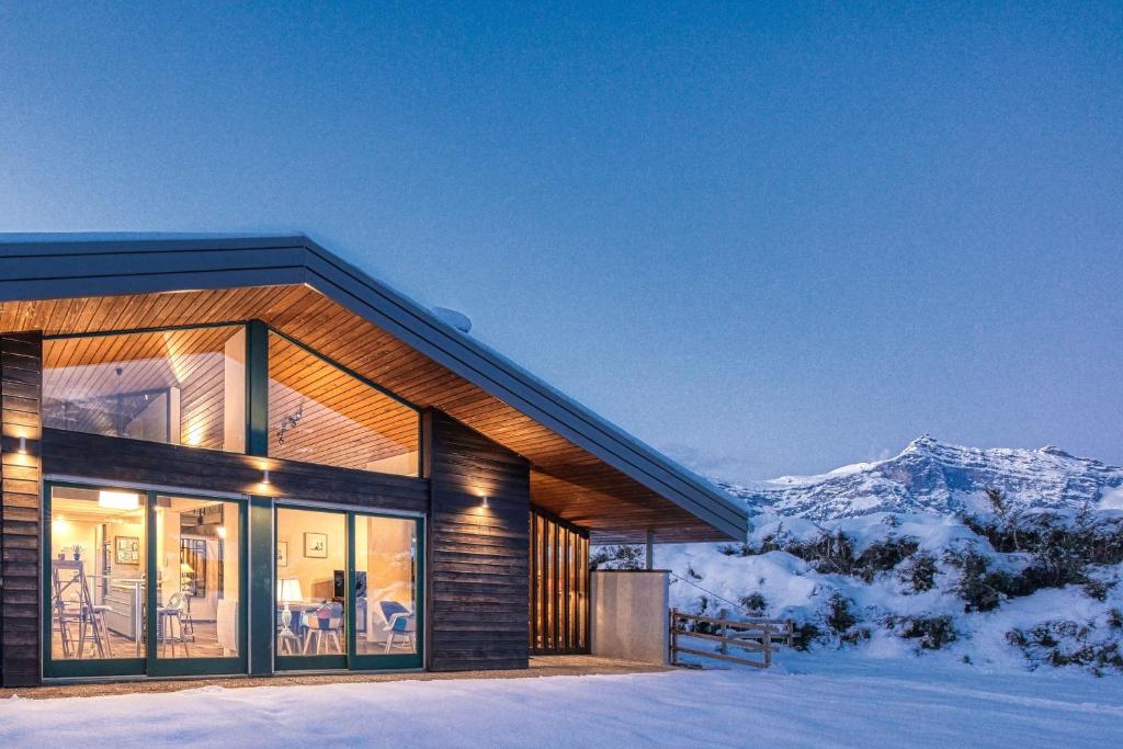 een huis in de sneeuw met bergen op de achtergrond bij Le Contemporain - Chalet vue sur le Mont Blanc in Saint-Gervais-les-Bains