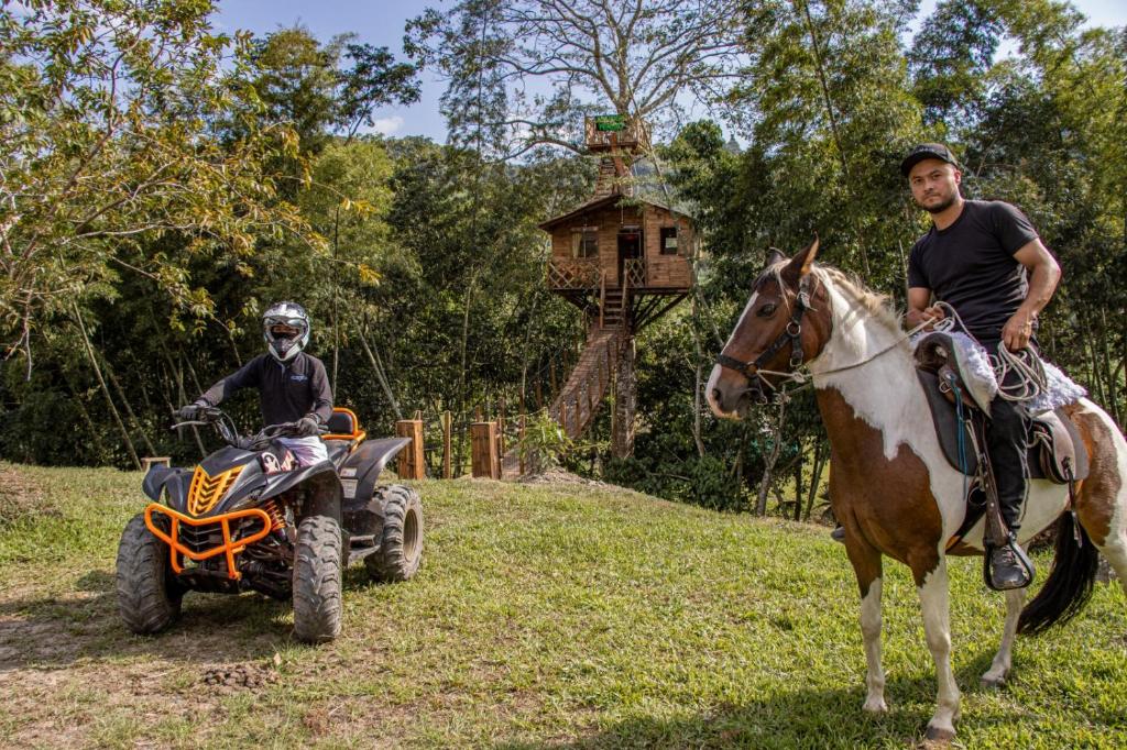 a man riding a horse and a man on a atv at Casa del árbol Mirador Peñero in La Peña
