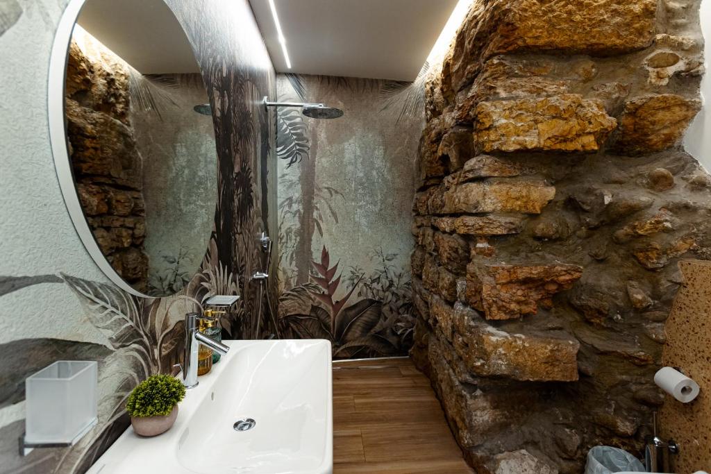 een badkamer met een wastafel en een stenen muur bij Un Nido Sull'Arena - Royal Welcome in Verona