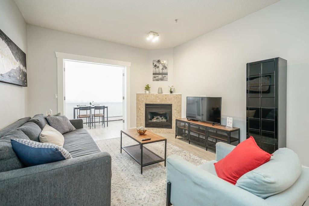 - un salon avec deux canapés et une cheminée dans l'établissement New Cozy 2 Bedrooms Condo w Parking, à Calgary