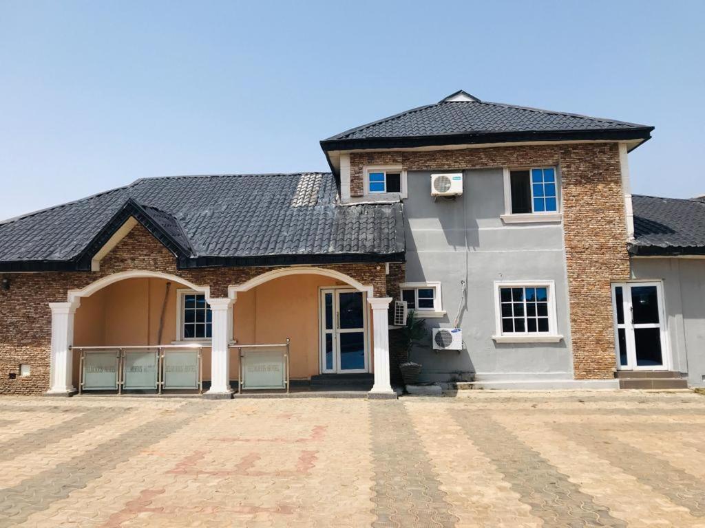 a large brick house with a black roof at Belmorris Hotel in Ilorin