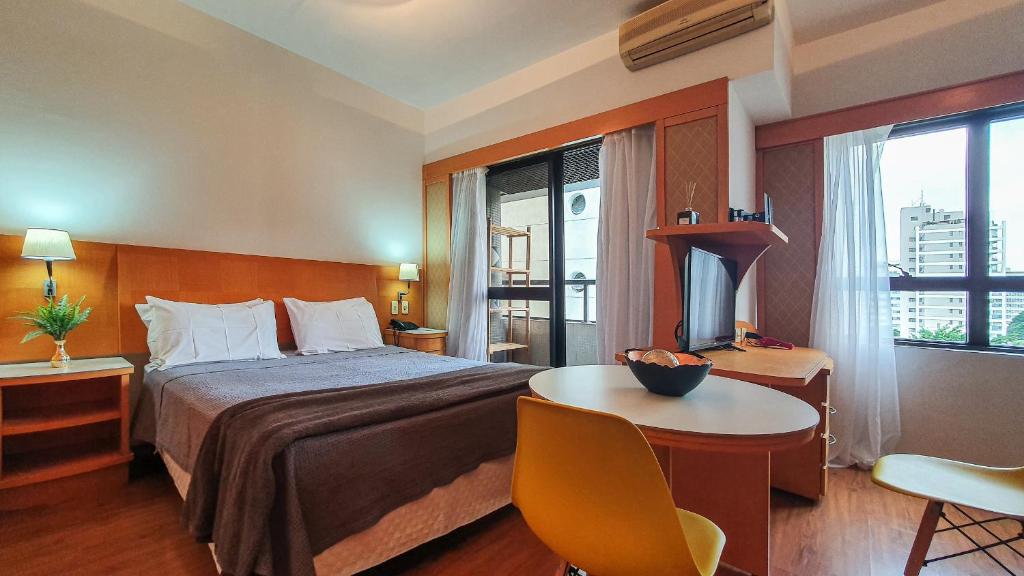 Habitación de hotel con cama, escritorio y TV. en Flat em Hotel 4 estrelas - Alameda Lorena, en São Paulo
