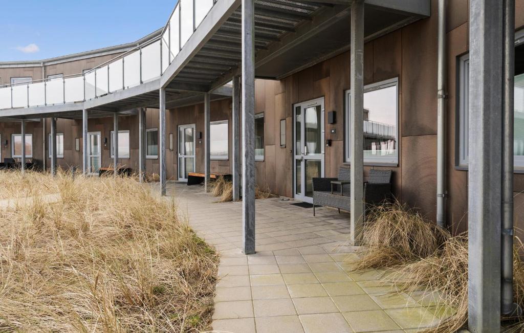 a building with a walkway in the middle of a field at Amazing Apartment In Ringkbing With Wifi in Ringkøbing