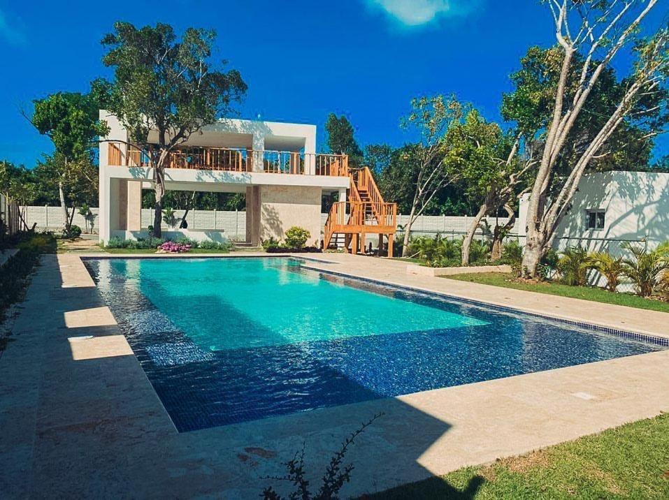 a house with a swimming pool in front of a house at TropicalvacationvillaEYS in Punta Cana