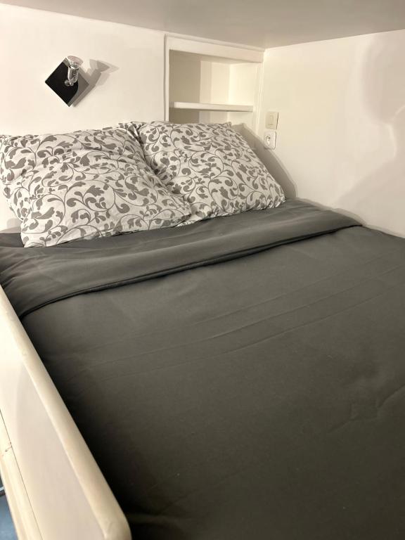 1 dormitorio con 1 cama con edredón blanco y negro en Le 4, en París