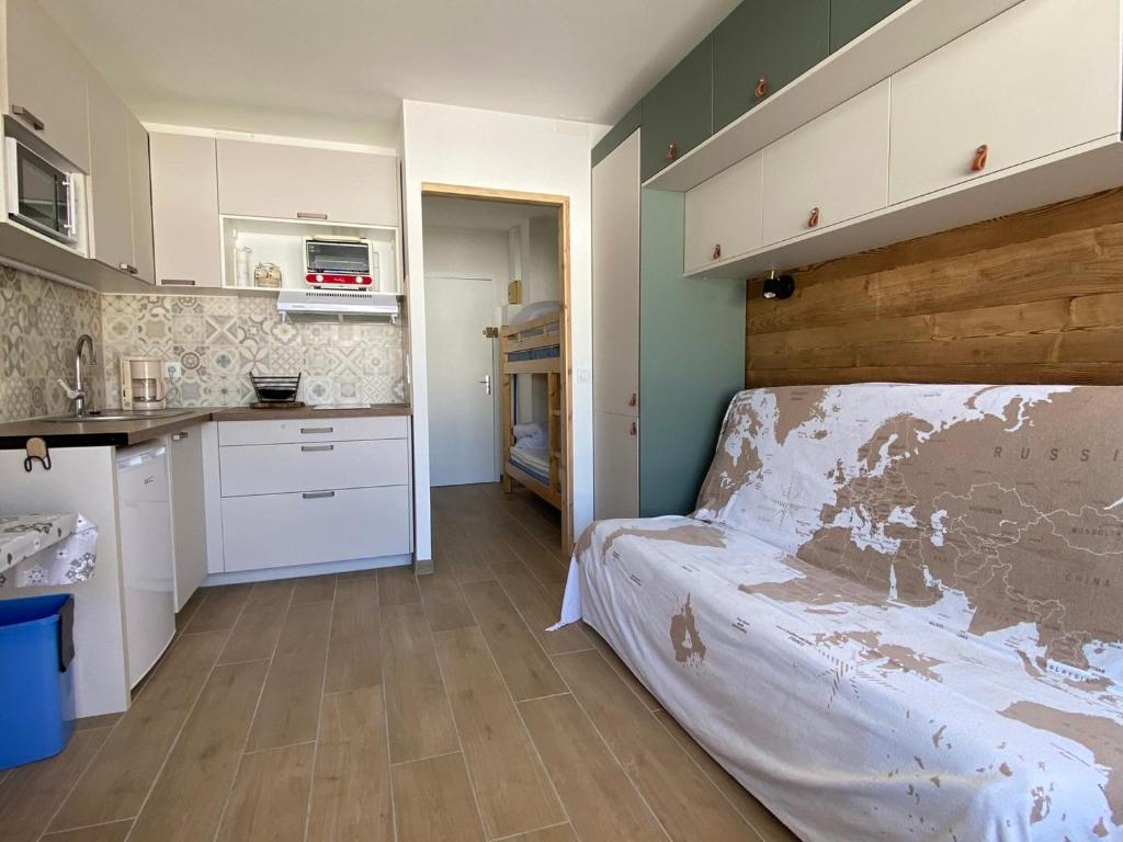 een kleine keuken met een bed in een kamer bij Studio La Joue du Loup, 1 pièce, 4 personnes - FR-1-504-185 in Le Dévoluy