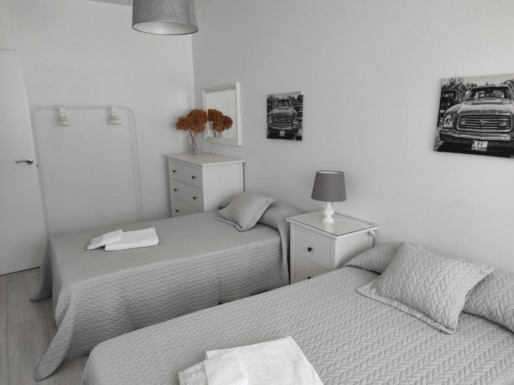 a bedroom with two beds and a lamp on a table at Apartamento Area Pequena Ézaro 2 in Ézaro