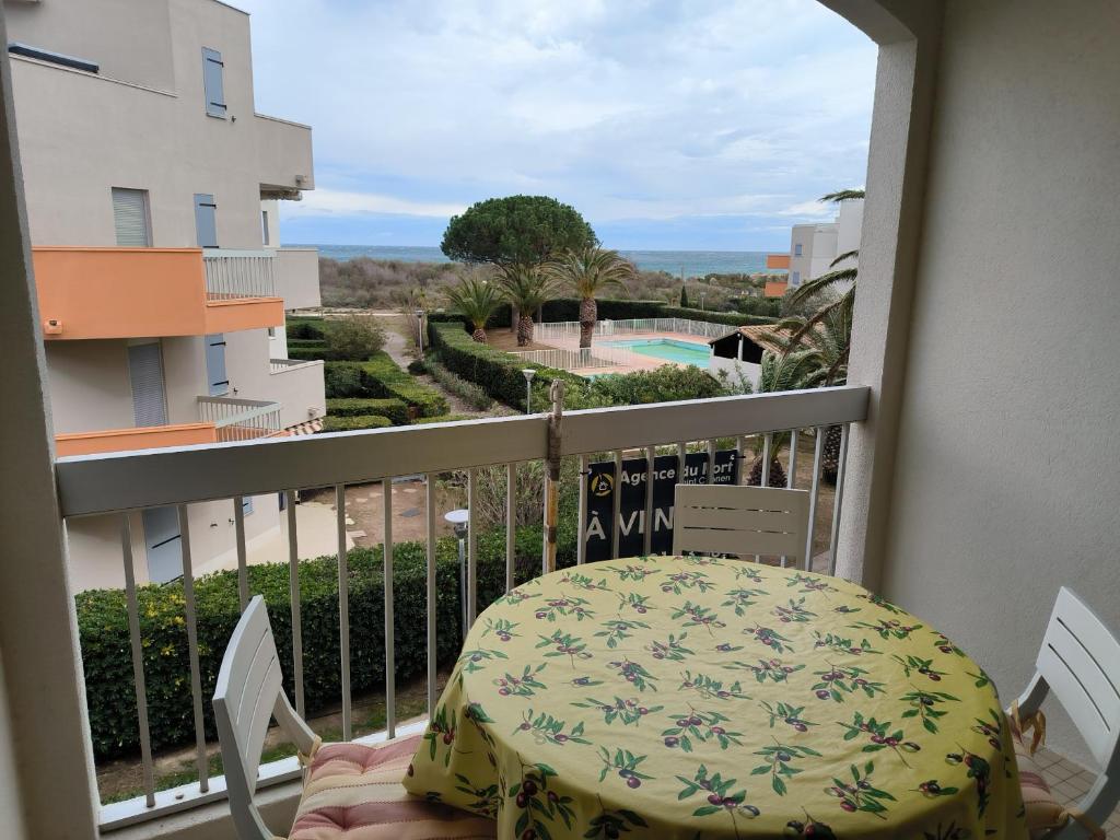 einen Balkon mit einem Tisch und Stühlen sowie Aussicht in der Unterkunft St Cyprien terrasse superbe vue sur la plage in Saint-Cyprien