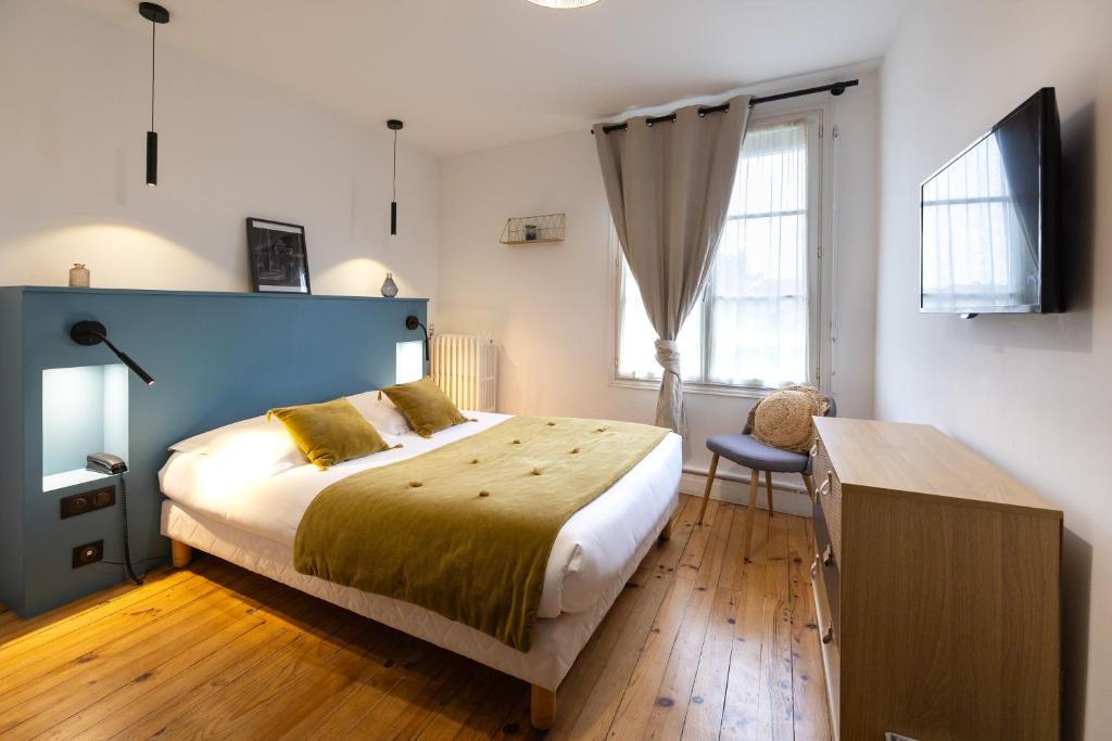 - une chambre avec un grand lit et une fenêtre dans l&#39;établissement Hotel de La Paix, à La Rochelle