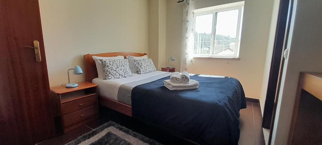 um quarto com uma cama com toalhas em Guesthouse, Ap Veríssimo na Nazaré