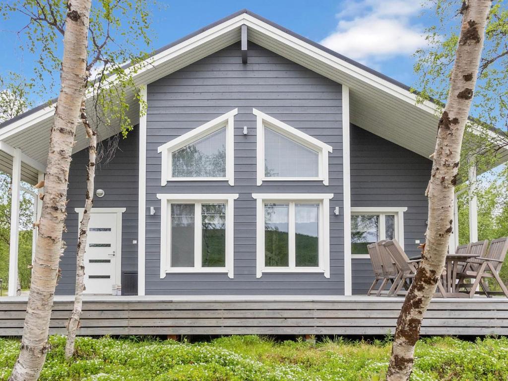 une maison grise avec deux chaises devant elle dans l'établissement Holiday Home Mökki tenolla by Interhome, à Utsjoki
