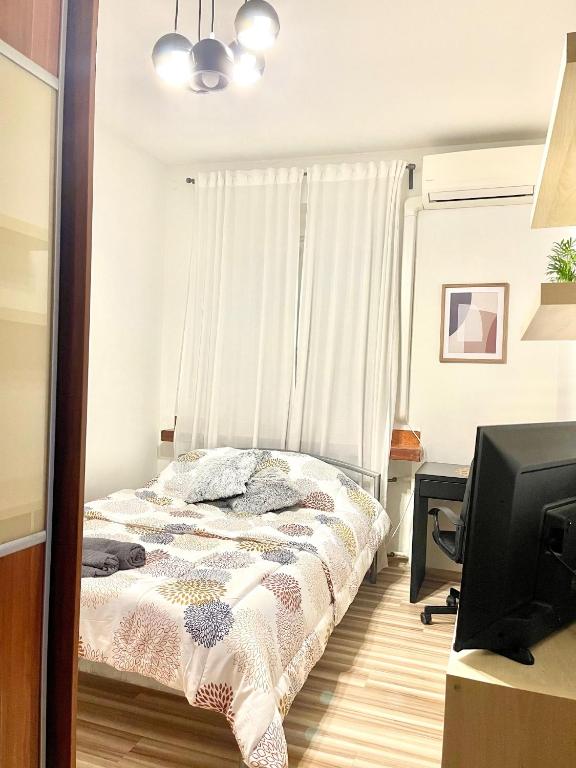 a bedroom with a bed and a desk and a television at Bratislava City Center in Nivy