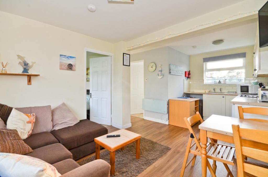 ein Wohnzimmer mit einem Sofa und einem Tisch in der Unterkunft 117 Sandown Bay in Sandown