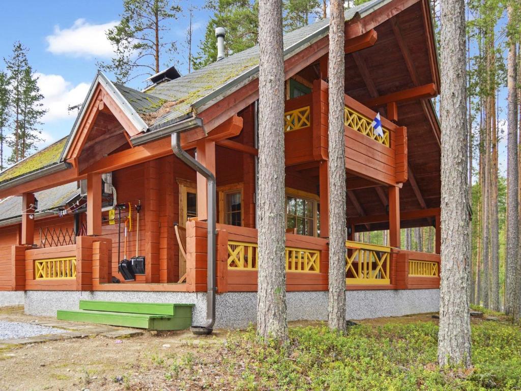a large wooden house in the woods with trees at Holiday Home Villa käpytikka by Interhome in Ylämylly