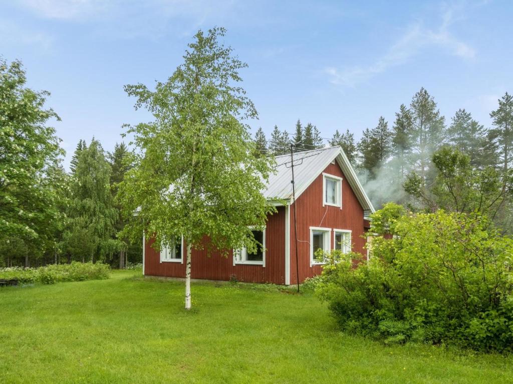 een rood huis met een boom in de tuin bij Holiday Home Käpylä by Interhome 