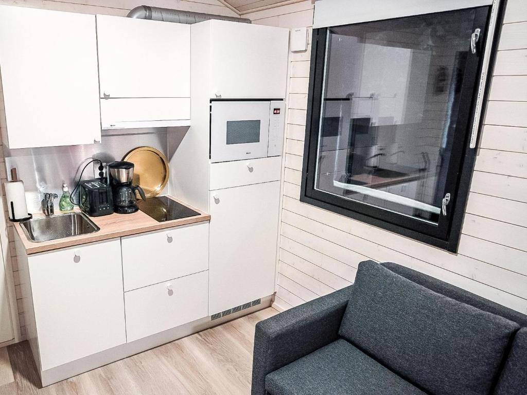 una piccola cucina con divano e forno a microonde di Holiday Home Rakkaranta a- lentäjän poika 1 by Interhome a Hyrynsalmi