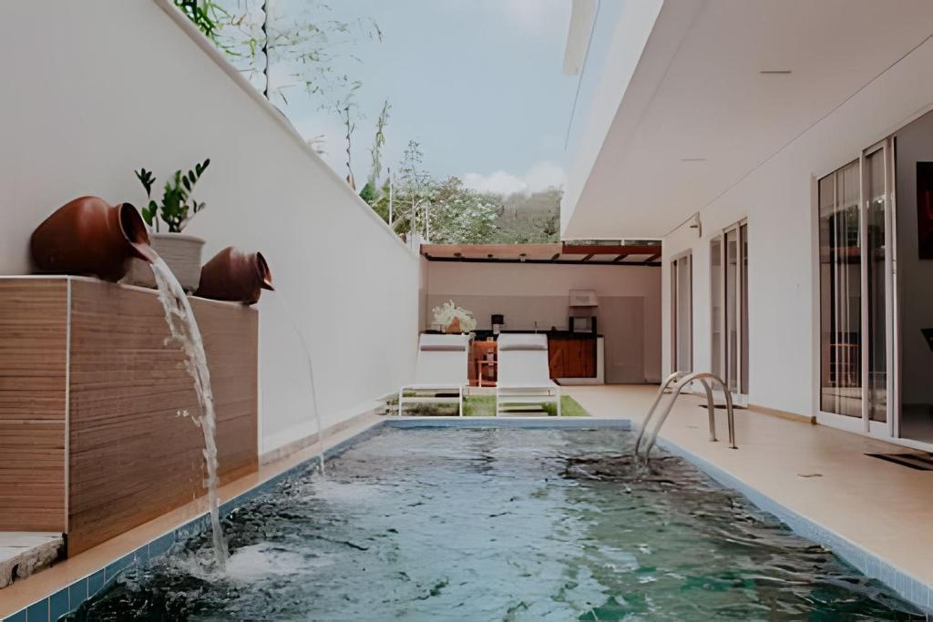 a pool in a house with a water fountain at Familia Pansini casa na Pipa in Pipa