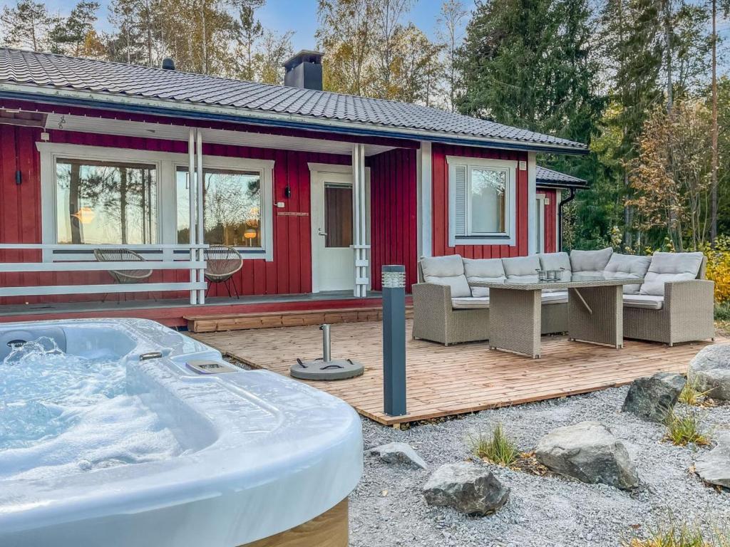 une maison rouge avec un bain à remous en face de celle-ci dans l'établissement Holiday Home Villa haave by Interhome, 