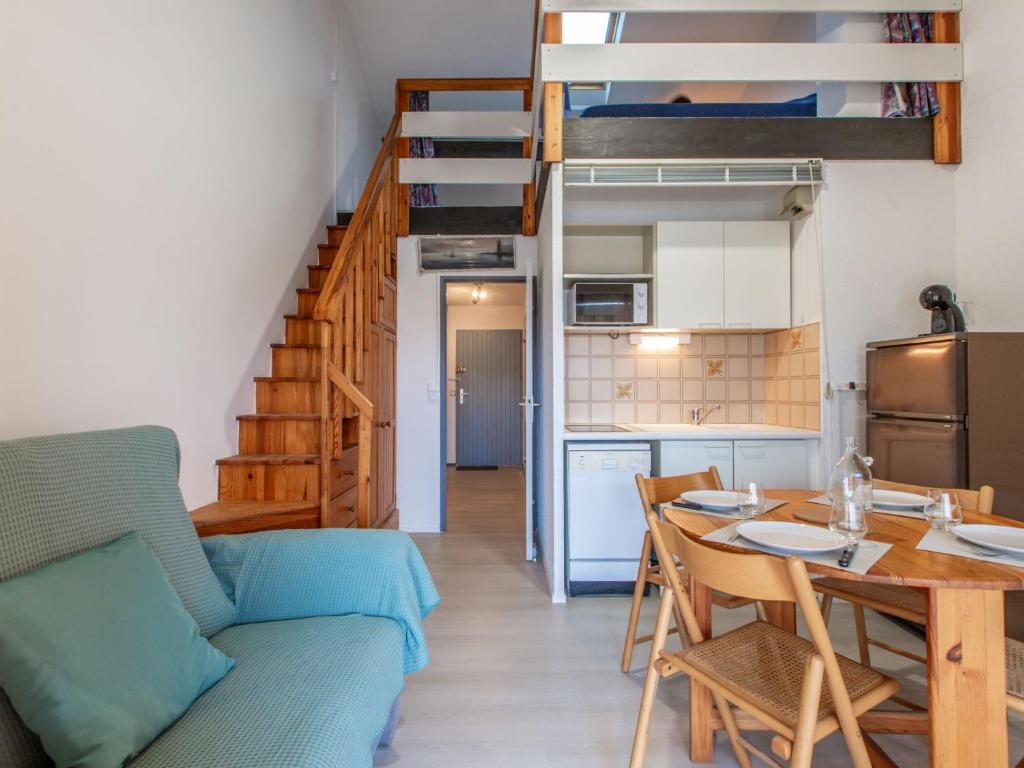 een woonkamer met een tafel en een hoogslaper bij Apartment Les Terrasses Notre Dame du Port-9 by Interhome in Capbreton