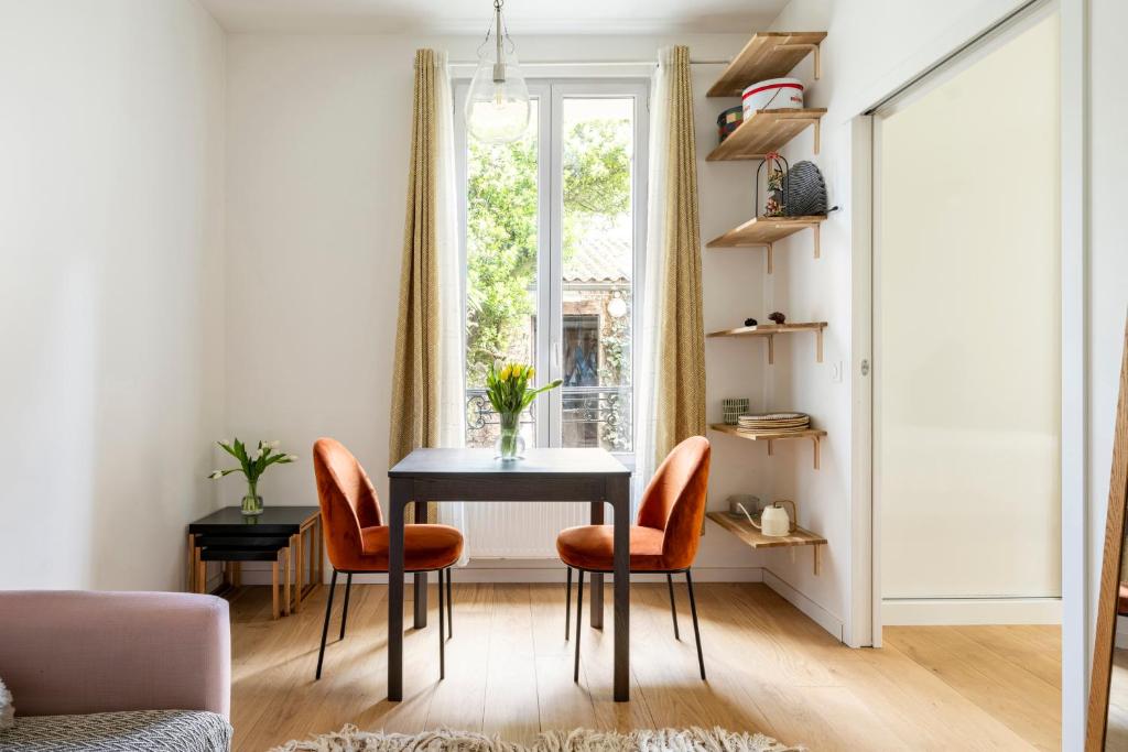 a dining room with a table and chairs and a window at Appartement Puteaux la Defense in Puteaux