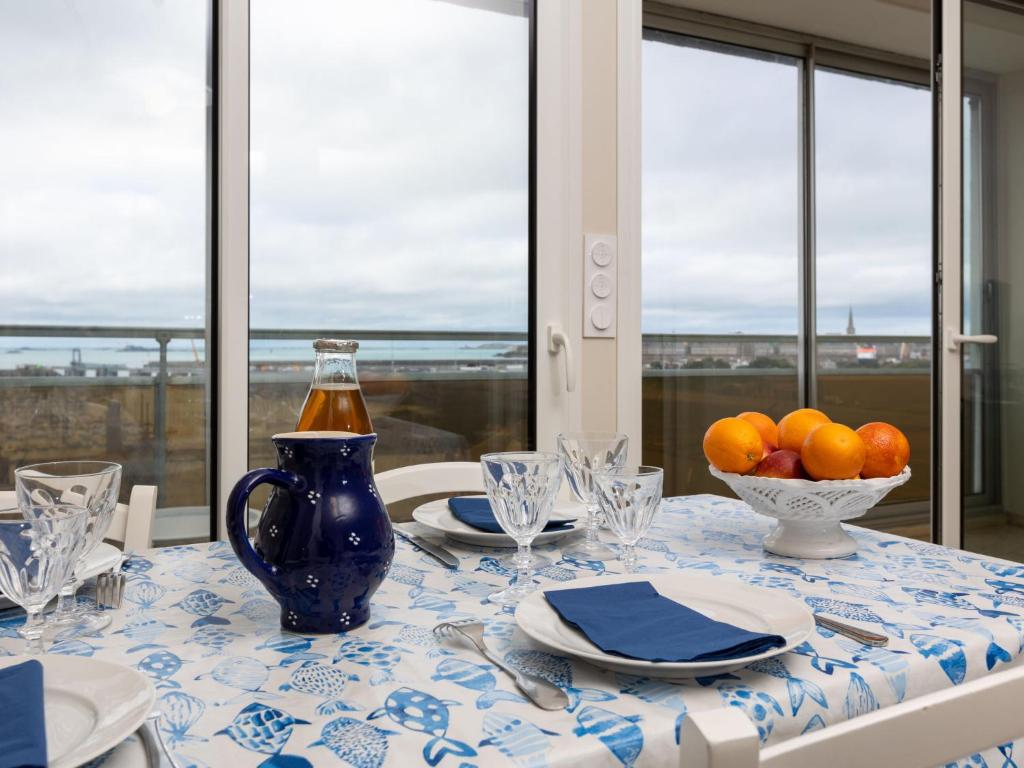 une table avec un chiffon de table bleu et blanc et un bol d'oranges dans l'établissement Apartment Bas-Sablons by Interhome, à Saint-Malo