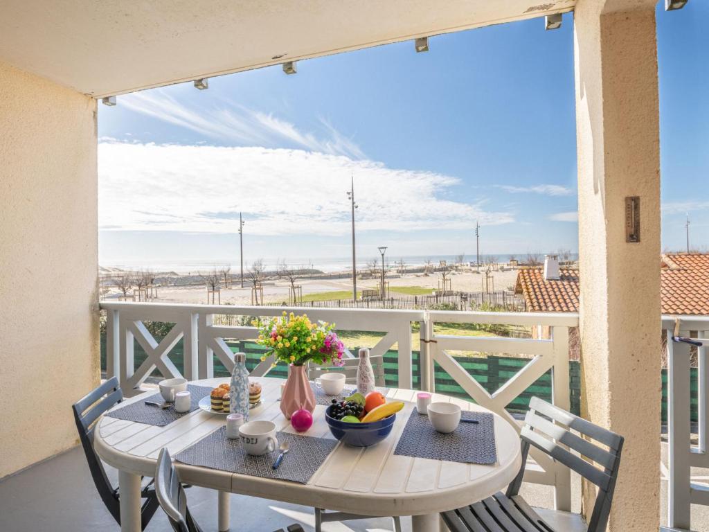 une table et des chaises sur un balcon avec vue sur la plage dans l'établissement Apartment Mon oxygène by Interhome, à Mimizan