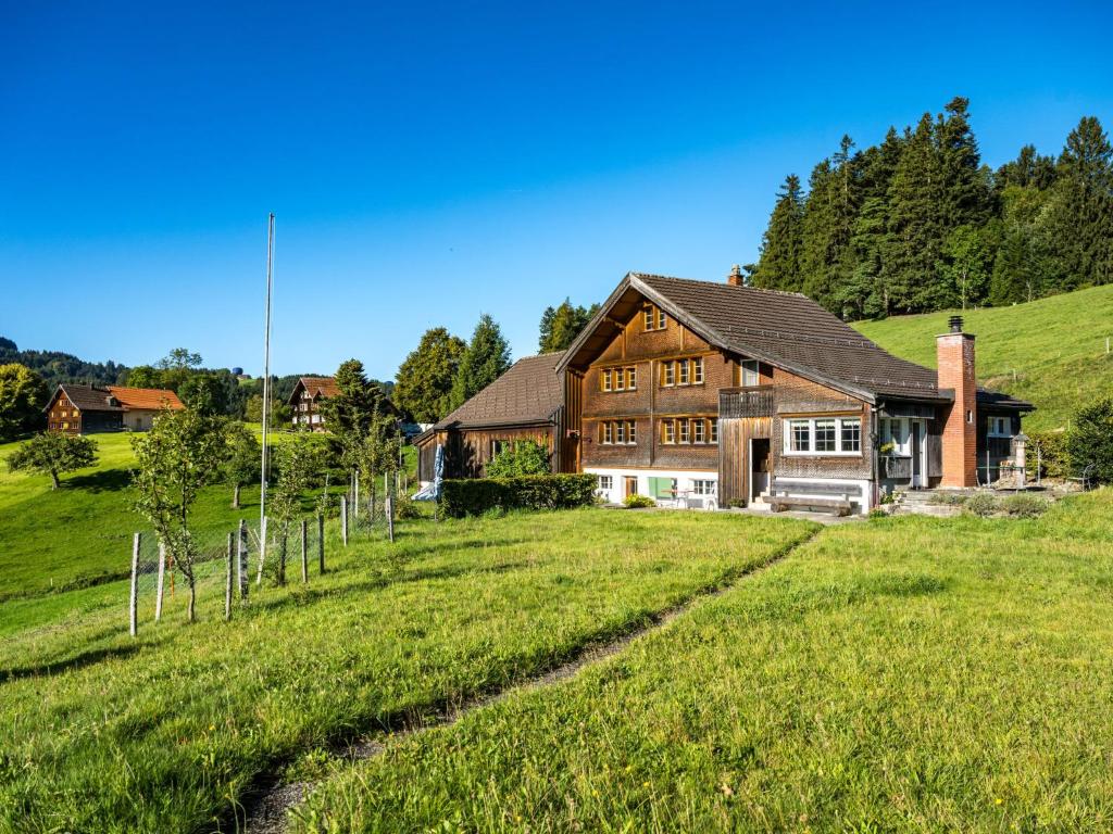 uma casa numa colina com um campo verde em Holiday Home Laderen 7 by Interhome em Oberegg